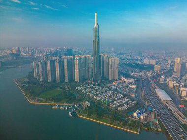 Aerial sunrise view at Landmark 81 - it is a super tall skyscraper and Saigon bridge with development buildings along Saigon river, cityscape in the beautiful morning with small fog around city