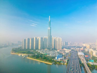 Aerial sunrise view at Landmark 81 - it is a super tall skyscraper and Saigon bridge with development buildings along Saigon river, cityscape in the beautiful morning with small fog around city