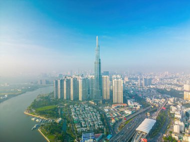 Aerial sunrise view at Landmark 81 - it is a super tall skyscraper and Saigon bridge with development buildings along Saigon river, cityscape in the beautiful morning with small fog around city