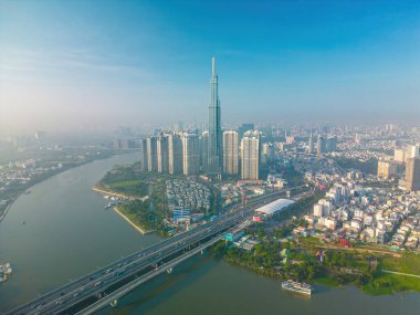 Aerial sunrise view at Landmark 81 - it is a super tall skyscraper and Saigon bridge with development buildings along Saigon river, cityscape in the beautiful morning with small fog around city