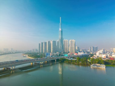Aerial sunrise view at Landmark 81 - it is a super tall skyscraper and Saigon bridge with development buildings along Saigon river, cityscape in the beautiful morning with small fog around city