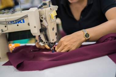 Ba Ria, VIETNAM - JAN 19 2023: Textile cloth factory working process tailoring workers equipment. This is a sewing machine factory production. portrait of professional Seamstress