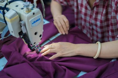 Ba Ria, VIETNAM - JAN 19 2023: Textile cloth factory working process tailoring workers equipment. This is a sewing machine factory production. portrait of professional Seamstress
