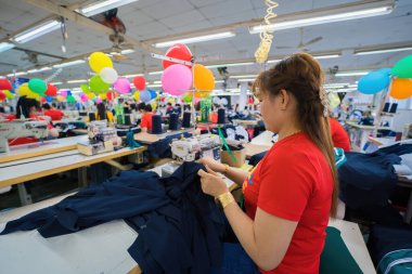 Ba Ria, VIETNAM - JAN 19 2023: Textile cloth factory working process tailoring workers equipment. This is a sewing machine factory production. portrait of professional Seamstress