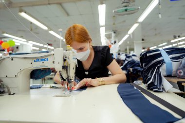 Ba Ria, VIETNAM - JAN 19 2023: Textile cloth factory working process tailoring workers equipment. This is a sewing machine factory production. portrait of professional Seamstress
