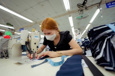 Ba Ria, VIETNAM - JAN 19 2023: Textile cloth factory working process tailoring workers equipment. This is a sewing machine factory production. portrait of professional Seamstress
