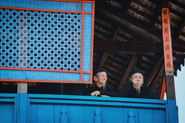 Vung Tau, Vietnam JAN 21 2023: Focus old man with traditional Vietnamese dress (ao ba ba) at Long Son house, this relic is also known as Ong Tran temple. A place of worship for Confucius