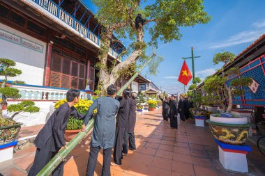 Vung Tau, Vietnam - JAN 21 2023: Raising Neu tree rituals in communal house at Long Son house. The bamboo pole placed in front of house on the last day of the lunar year to expel evils