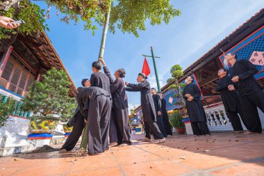 Vung Tau, Vietnam - JAN 21 2023: Raising Neu tree rituals in communal house at Long Son house. The bamboo pole placed in front of house on the last day of the lunar year to expel evils