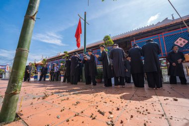 Vung Tau, Vietnam - JAN 21 2023: Raising Neu tree rituals in communal house at Long Son house. The bamboo pole placed in front of house on the last day of the lunar year to expel evils