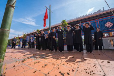 Vung Tau, Vietnam - JAN 21 2023: Raising Neu tree rituals in communal house at Long Son house. The bamboo pole placed in front of house on the last day of the lunar year to expel evils