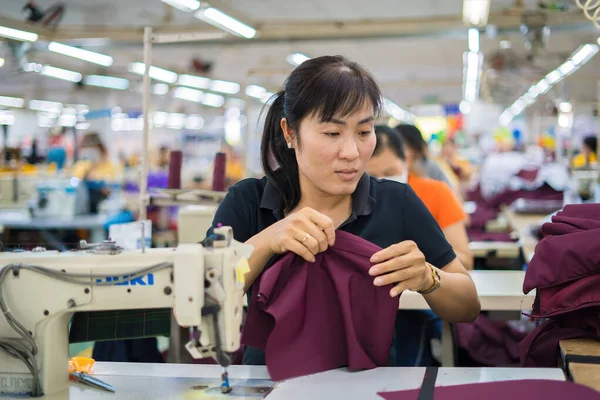 Ba Ria, VIETNAM - JAN 19 2023: Textile cloth factory working process tailoring workers equipment. This is a sewing machine factory production. portrait of professional Seamstress