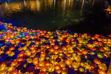 Floating colored lanterns and garlands on river at night on Vesak day day for celebrating Buddha's birthday at night, that made from paper and candle. Commemorating those who have passed away
