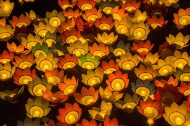 Floating colored lanterns and garlands on river at night on Vesak day day for celebrating Buddha's birthday at night, that made from paper and candle. Commemorating those who have passed away