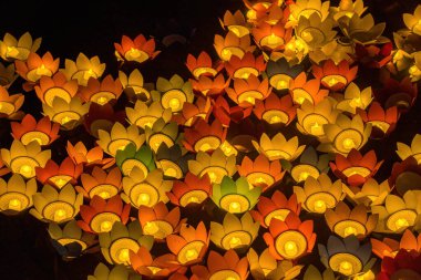 Floating colored lanterns and garlands on river at night on Vesak day day for celebrating Buddha's birthday at night, that made from paper and candle. Commemorating those who have passed away