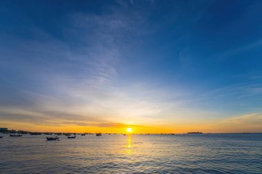 Beautiful cloudscape over the sea, sunrise shot. Lonely boats. Calm sea with sunset sky and sun through the clouds over. Calm sea with sunset sky or sunrise and sun through the clouds over.