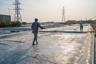 Vung Tau, VIETNAM - 25 Şubat 2023: Long Dien kırsal kesiminde tuz deposundaki tuz yığınından yapılan deniz tuzu işlemi. Tuz tarlaları Vietnam 'ın en eşsiz yerlerinden biridir.