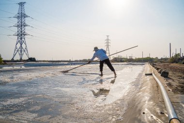 Vung Tau, VIETNAM - 25 Şubat 2023: Long Dien kırsal kesiminde tuz deposundaki tuz yığınından yapılan deniz tuzu işlemi. Tuz tarlaları Vietnam 'ın en eşsiz yerlerinden biridir.