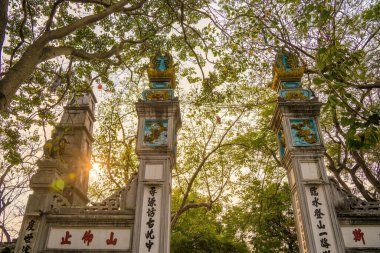 Ngoc Son Pagoda girişi Hoan Kiem Gölü 'nün kırmızı köprüsü, Hanoi, Vietnam. Ngoc Son Tapınağı, edebiyattaki en parlak yıldızlardan biri olarak kabul edilen azize olarak kabul edilir..