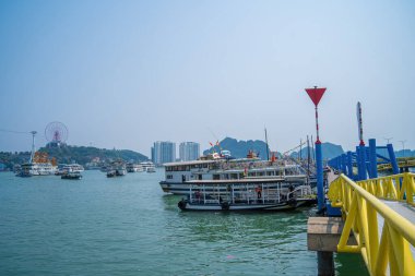 Bai Chay köprüsü ve güneş tekerleği sabahın erken saatlerinde Ha Long, Vietnam 'da güzel bulutlarla. Marina, Boats, Ferris Wheel ve Askı Köprüsü. Hepsi Bai Chay Sahili 'nde.
