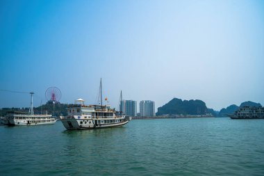 Bai Chay köprüsü ve güneş tekerleği sabahın erken saatlerinde Ha Long, Vietnam 'da güzel bulutlarla. Marina, Boats, Ferris Wheel ve Askı Köprüsü. Hepsi Bai Chay Sahili 'nde.