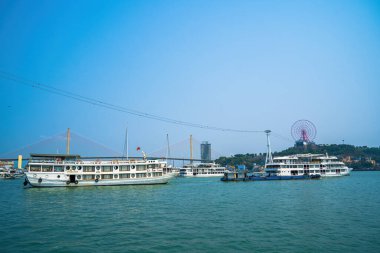 Bai Chay köprüsü ve güneş tekerleği sabahın erken saatlerinde Ha Long, Vietnam 'da güzel bulutlarla. Marina, Boats, Ferris Wheel ve Askı Köprüsü. Hepsi Bai Chay Sahili 'nde.