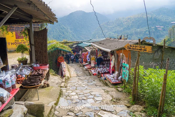 stock image Lao Cai, Vietnam- MAR 12 2023: Beautiful scenery of Cat Cat village,a highland cultural village in Sapa. Street in Cat Cat Hmong village by Sapa with market full of traditional colorful clothes