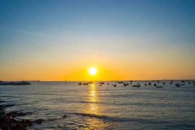 Beautiful cloudscape over the sea, sunrise shot. Lonely boats. Calm sea with sunset sky and sun through the clouds over. Calm sea with sunset sky or sunrise and sun through the clouds over.