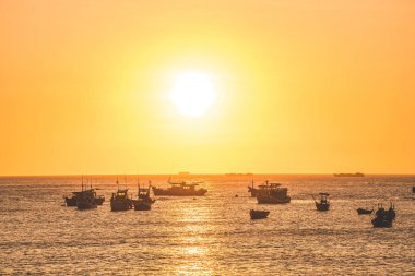 Beautiful cloudscape over the sea, sunrise shot. Lonely boats. Calm sea with sunset sky and sun through the clouds over. Calm sea with sunset sky or sunrise and sun through the clouds over.