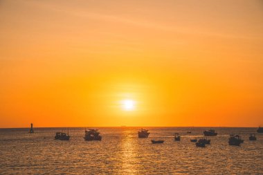 Beautiful cloudscape over the sea, sunrise shot. Lonely boats. Calm sea with sunset sky and sun through the clouds over. Calm sea with sunset sky or sunrise and sun through the clouds over.