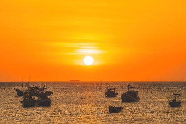 Beautiful cloudscape over the sea, sunrise shot. Lonely boats. Calm sea with sunset sky and sun through the clouds over. Calm sea with sunset sky or sunrise and sun through the clouds over.