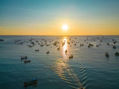 Beautiful cloudscape over the sea, sunrise shot. Lonely boats. Calm sea with sunset sky and sun through the clouds over. Calm sea with sunset sky or sunrise and sun through the clouds over.