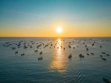 Beautiful cloudscape over the sea, sunrise shot. Lonely boats. Calm sea with sunset sky and sun through the clouds over. Calm sea with sunset sky or sunrise and sun through the clouds over.