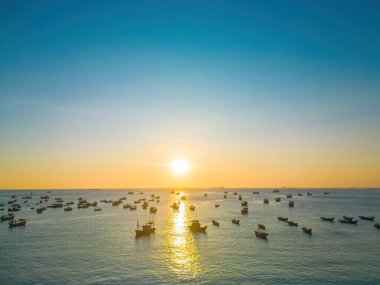 Beautiful cloudscape over the sea, sunrise shot. Lonely boats. Calm sea with sunset sky and sun through the clouds over. Calm sea with sunset sky or sunrise and sun through the clouds over.