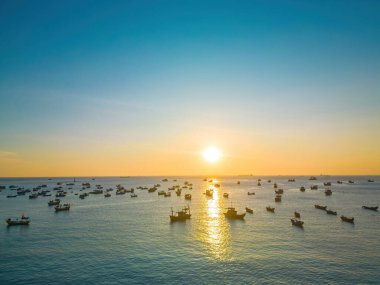Beautiful cloudscape over the sea, sunrise shot. Lonely boats. Calm sea with sunset sky and sun through the clouds over. Calm sea with sunset sky or sunrise and sun through the clouds over.
