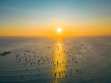 Beautiful cloudscape over the sea, sunrise shot. Lonely boats. Calm sea with sunset sky and sun through the clouds over. Calm sea with sunset sky or sunrise and sun through the clouds over.