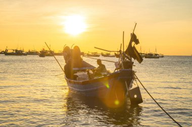 Vung Tau, VIETNAM MAR 25 2023: Balıkçı ağlarını gün doğumunda ya da günbatımında tekneye atıyor. Geleneksel balıkçılar balık ağını hazırlıyor.