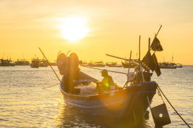 Vung Tau, VIETNAM MAR 25 2023: Balıkçı ağlarını gün doğumunda ya da günbatımında tekneye atıyor. Geleneksel balıkçılar balık ağını hazırlıyor.