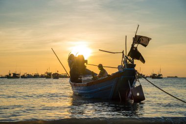Vung Tau, VIETNAM MAR 25 2023: Balıkçı ağlarını gün doğumunda ya da günbatımında tekneye atıyor. Geleneksel balıkçılar balık ağını hazırlıyor.
