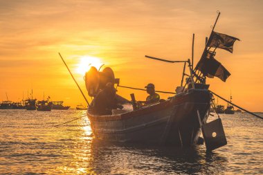 Vung Tau, VIETNAM MAR 25 2023: Balıkçı ağlarını gün doğumunda ya da günbatımında tekneye atıyor. Geleneksel balıkçılar balık ağını hazırlıyor.
