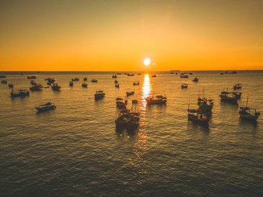 Beautiful cloudscape over the sea, sunrise shot. Lonely boats. Calm sea with sunset sky and sun through the clouds over. Calm sea with sunset sky or sunrise and sun through the clouds over.