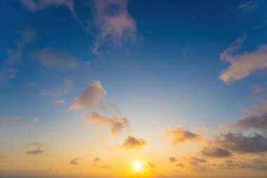 Arka plan bulutu yazı. Bulutlu yaz. Gün batımı ve güneş ışınlarıyla gökyüzü bulutsuz. Doğal gökyüzü sinematik güzel sarı ve beyaz doku arkaplanı