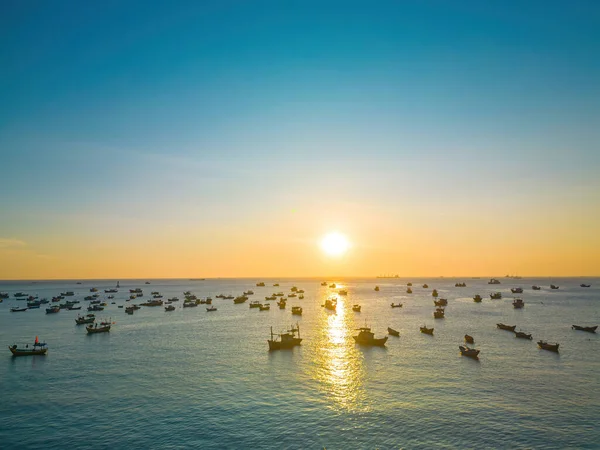 Beautiful cloudscape over the sea, sunrise shot. Lonely boats. Calm sea with sunset sky and sun through the clouds over. Calm sea with sunset sky or sunrise and sun through the clouds over.