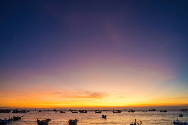 Beautiful cloudscape over the sea, sunrise shot. Lonely boats. Calm sea with sunset sky and sun through the clouds over. Calm sea with sunset sky or sunrise and sun through the clouds over.