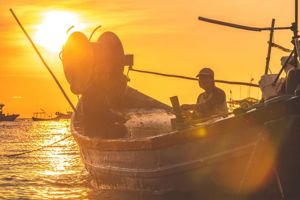 stock image Vung Tau, VIETNAM MAR 25 2023: Fisherman casting his net on the boat at the sunrise or sunset. Traditional fishermen prepare the fishing net