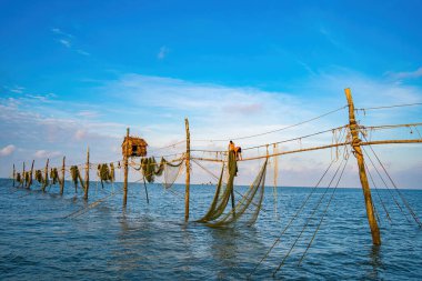 Güneşin doğuşunda iki balıkçı oltalara ağ atıyor. Geleneksel balıkçılar balıkçı ağını hazırlıyorlar, yerel halk buna Day hang khoi diyor. Balıkçılık ve günlük yaşam konsepti.