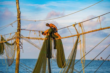 Güneşin doğuşunda iki balıkçı oltalara ağ atıyor. Geleneksel balıkçılar balıkçı ağını hazırlıyorlar, yerel halk buna Day hang khoi diyor. Balıkçılık ve günlük yaşam konsepti.
