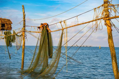 Güneşin doğuşunda iki balıkçı oltalara ağ atıyor. Geleneksel balıkçılar balıkçı ağını hazırlıyorlar, yerel halk buna Day hang khoi diyor. Balıkçılık ve günlük yaşam konsepti.