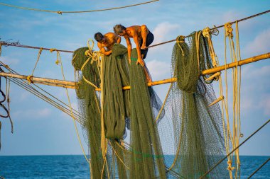 Güneşin doğuşunda iki balıkçı oltalara ağ atıyor. Geleneksel balıkçılar balıkçı ağını hazırlıyorlar, yerel halk buna Day hang khoi diyor. Balıkçılık ve günlük yaşam konsepti.