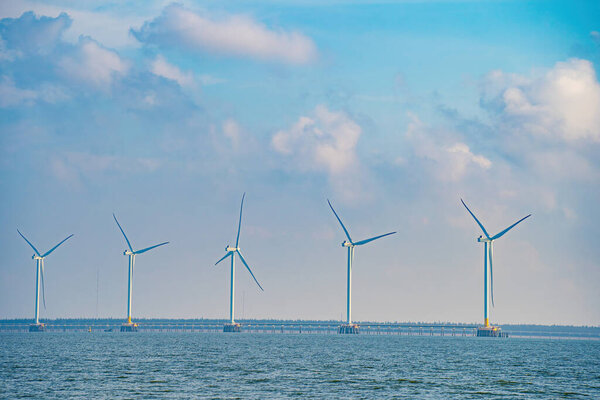 Panoramic view of wind farm at sea, with high wind turbines for generation electricity with copy space at Tra Vinh, Viet Nam. Green energy concept. Eco concpept